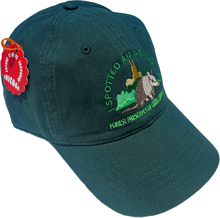 Dark green baseball cap embroidered with an illustration showing an armadillo walking through vegetation in front of the Chicago Skyline, labeled “I Spotted an Armadillo – Forest Preserves of Cook County.”